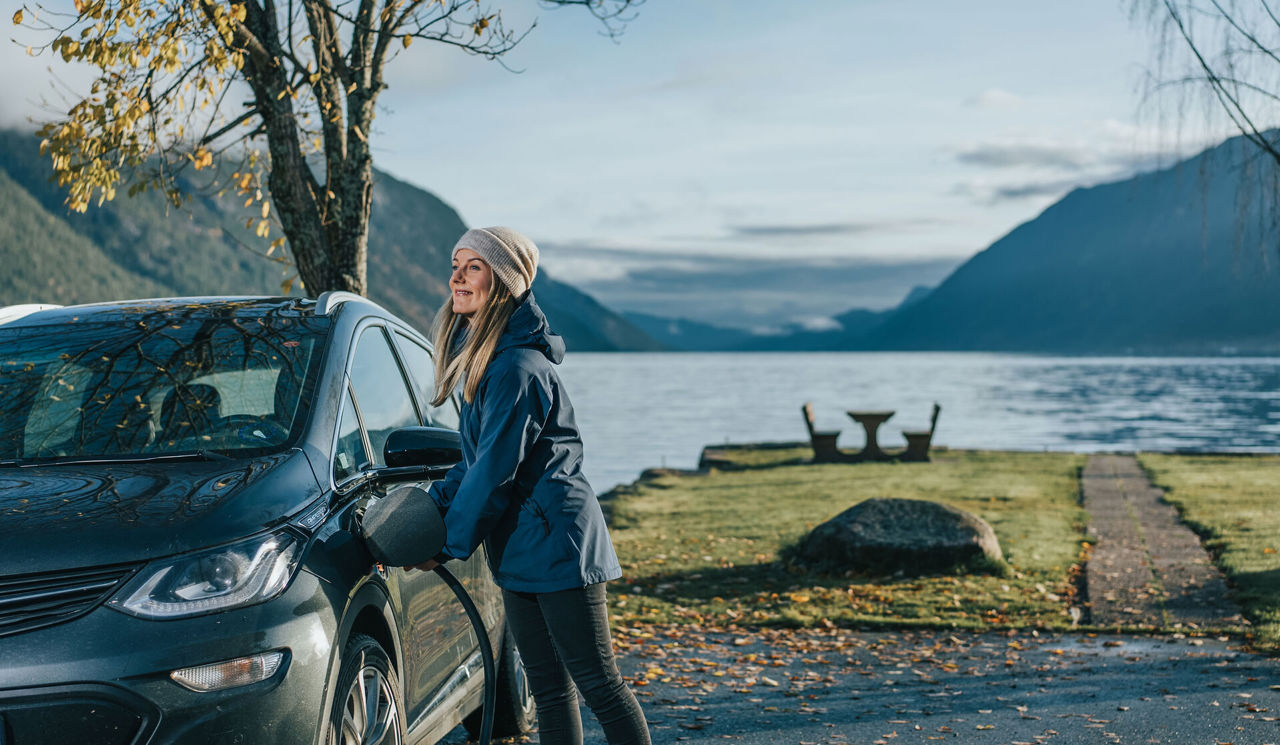 Woman using EV charging on her car